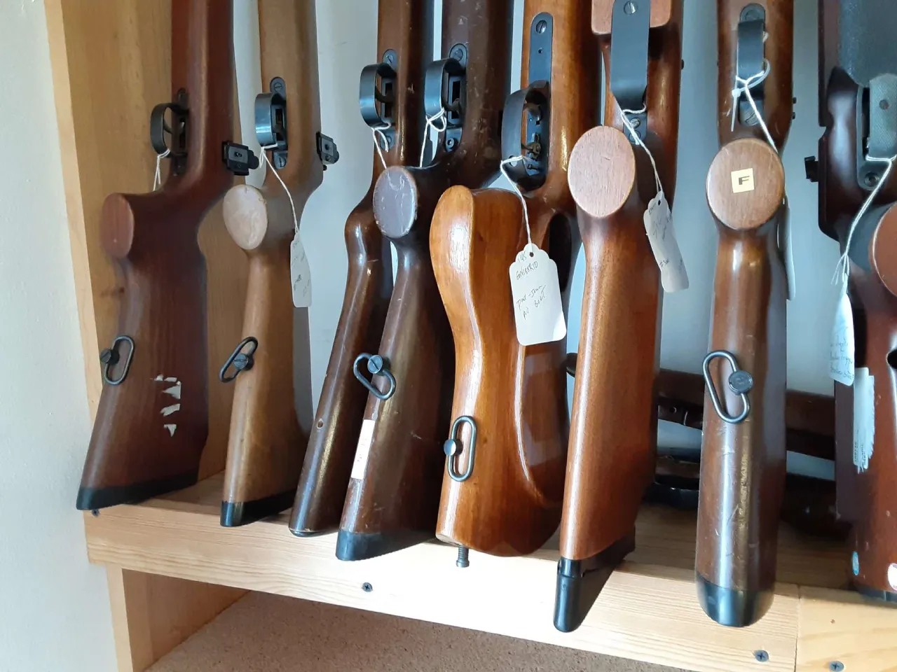 Rack of tagged rifle stocks on a retail inventory shelf